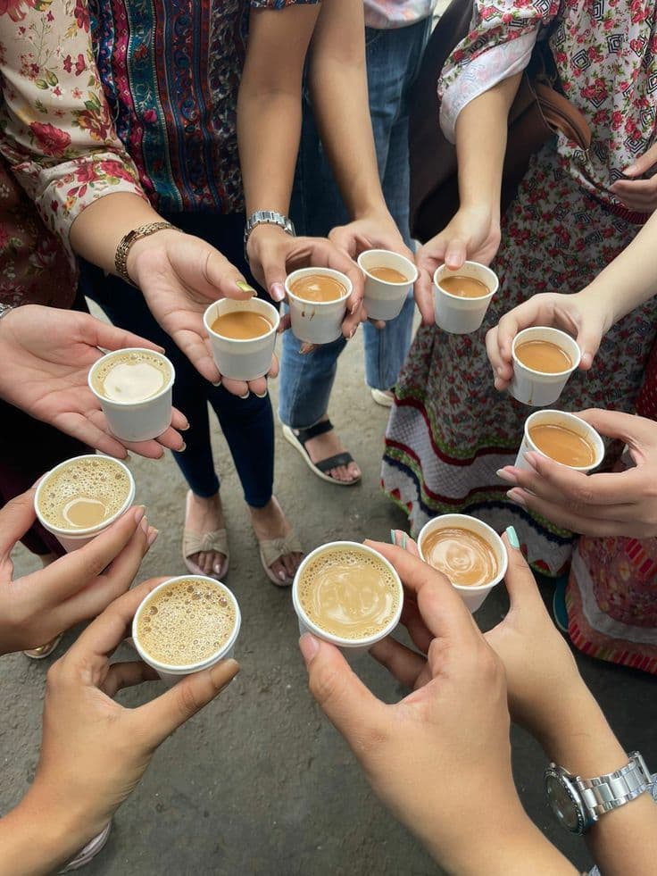 Colleagues holding cups of chai together at a Chatkharay Express hi-tea